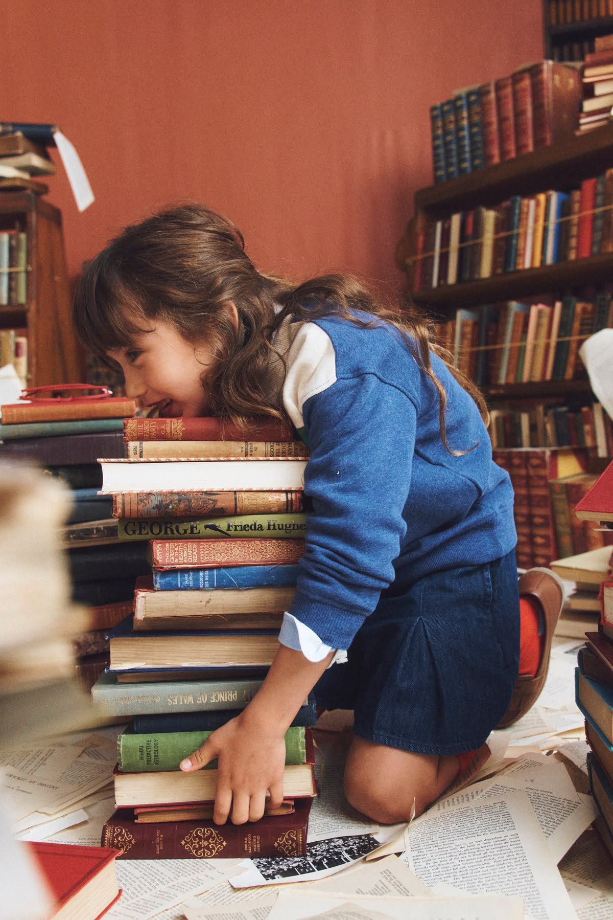 Bambina appoggiata a una pila di libri
