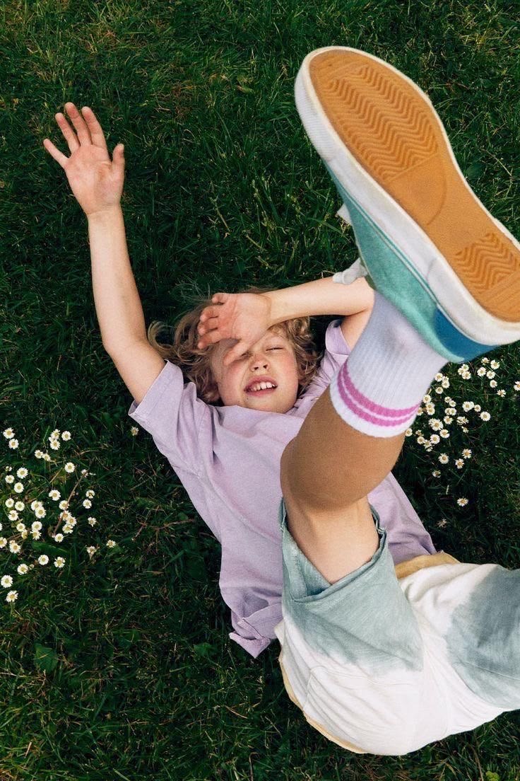 Bambina che gioca nell'erba tra le margherite